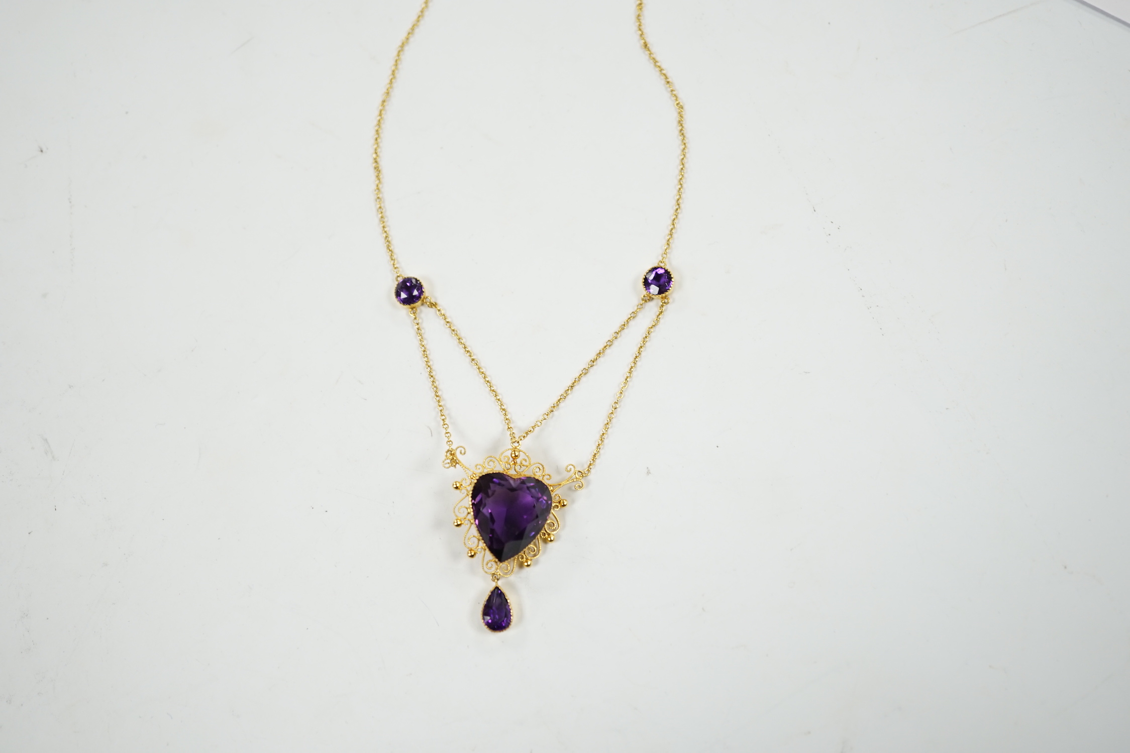 A Victorian style 9ct and four stone amethyst drop pendant necklace, the pendant set with heart shaped central stone and pear cut drop, overall 46cm, gross weight 8 grams.